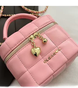 Détails du sac matelassé rose avec pendentif coeur doré et double fermeture éclair