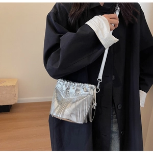 Details der silbernen Metallic-Fransenbeuteltasche mit modischen Quasten und Riemen