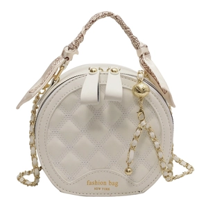 Sac à main rond matelassé blanc avec chaîne dorée et poignée ornée d'un foulard