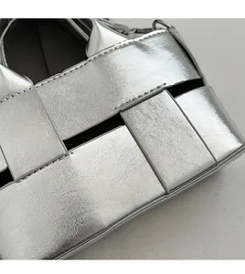 Close-up of silver woven handbag showing intricate texture and high-quality stitching detail