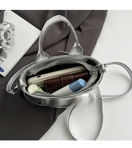 Top view of spacious silver metallic tote interior with phone, wallet and cosmetics