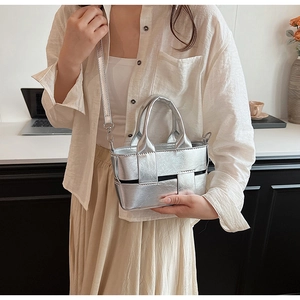Detail of silver metallic woven handbag with chunky square texture and crossbody strap