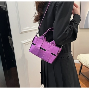 Detail of purple metallic woven handbag with top handle and thin shoulder strap