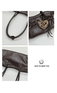 Détail du sac cabas marron foncé avec texture cuir et breloque cœur léopard