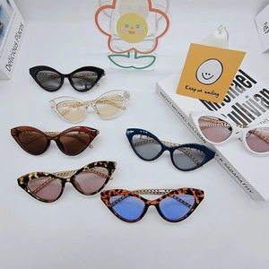 Various cat-eye sunglasses featuring golden metal chain temples on a clean white layout