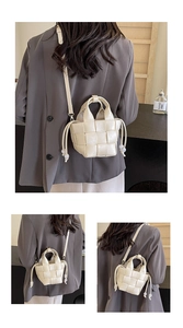Détail du sac seau tressé avec grand motif quadrillé et détails de perles de serrage