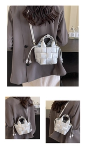 Détails du sac seau tissé argenté avec texture en cuir et fermeture par cordon de serrage
