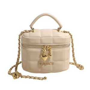 Sac seau matelassé blanc crème avec bandoulière chaîne dorée et pendentif en cœur