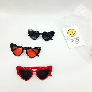 Three pairs of heart-shaped kids sunglasses in black and red frames on white background