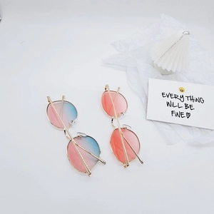Détail de lunettes de soleil rondes dégradées pour enfants avec monture métallique dorée