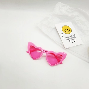 Detailed close-up of pink heart-shaped sunglasses with stylish translucent lenses