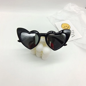 Close-up of heart-shaped kids sunglasses on a bubble candle for a trendy aesthetic