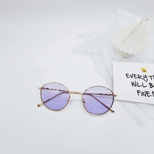 Détail de lunettes de soleil rondes vintage en métal avec verres violets et monture dorée