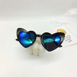 Detail of heart-shaped sunglasses with blue reflective lenses on a candle stand