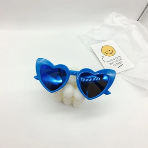 Detail view of heart-shaped sunglasses in vibrant blue with reflective mirrored lenses