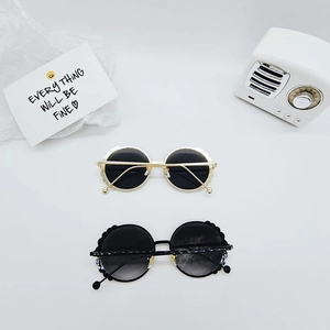 Kids round petal-edge sunglasses in gold and black metal frames with retro aesthetic