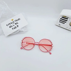 Detailed view of pink round frame kids sunglasses with elegant pearl embellishments