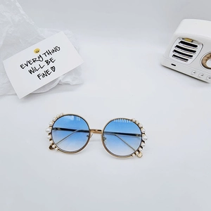 Detailed view of round metal kids' sunglasses with pearl inlay and blue gradient lenses