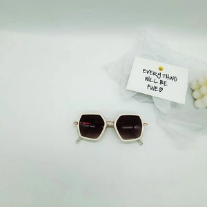 Detail of white hexagonal kids sunglasses with metal hinges on a minimalist background