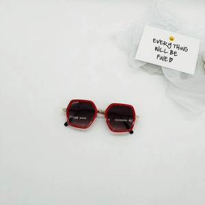 Close-up of red hexagonal children's sunglasses with gradient lenses and gold metal hinges