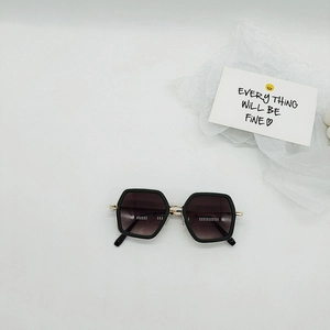 Macro view of geometric kids sunglasses with black hexagonal frames and gold accents