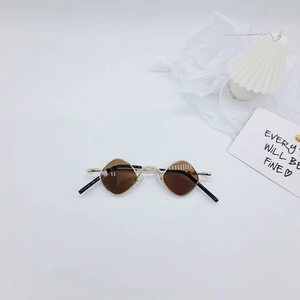 Détail de lunettes de soleil enfant monture métal doré losange et verres marron