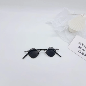 Détail de lunettes de soleil rétro pour enfants avec monture métal et verres losanges