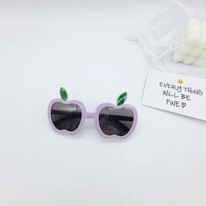 Macro detail of apple-shaped kids sunglasses in lavender purple with green leaf accents