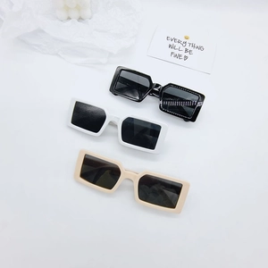 Lunettes de soleil enfant monture carrée en noir blanc et beige sur fond blanc épuré