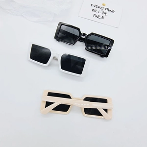 Vue détaillée de lunettes de soleil rétro pour enfants avec monture épaisse en noir et blanc