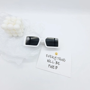 Gros plan de lunettes de soleil rectangulaires blanches sur des accessoires artistiques