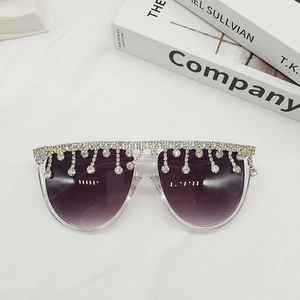 Détail de lunettes de soleil à franges de strass et verres dégradés violets sur fond blanc