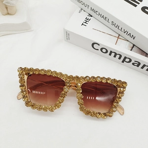 Detail of luxury cat-eye sunglasses with gradient brown lenses and sparkling crystals