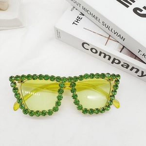 Detail of cat-eye sunglasses with green rhinestones and translucent yellow lenses