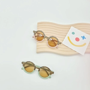 Kids round sunglasses with leopard print and pastel frames on a wooden display