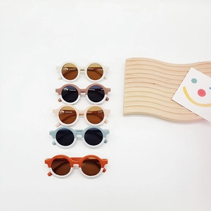 Kids round sunglasses with two-tone frames in five colors on a clean white background