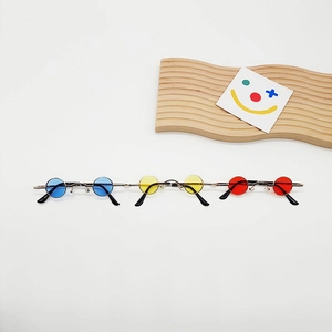Top view of three mini retro round sunglasses in blue yellow and red colors with gold frames