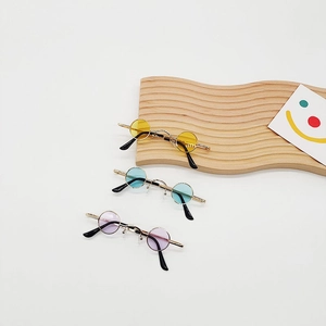 Three pairs of vintage round mini sunglasses in yellow blue and purple with metal frames