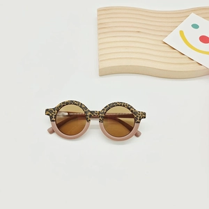 Close-up of kids round leopard and pink sunglasses on a decorative wooden stand