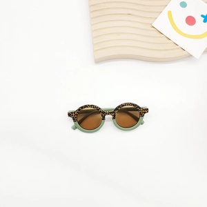 Detailed view of kids round sunglasses featuring leopard print and light green frame