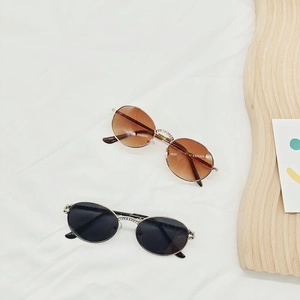 Retro oval metal frame sunglasses for children with rhinestone details on soft fabric
