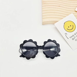Detailansicht der schwarzen Kinder-Sonnenbrille in Blumenform mit Smiley-Karte