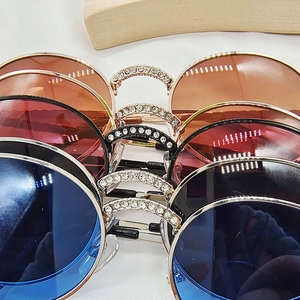 Close-up of stylish kids' round sunglasses with glitter-embellished metallic frames