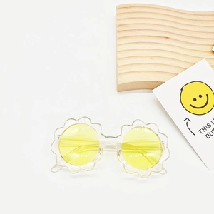 Detailaufnahme der gelben runden Gläser und des transparenten Blumenrahmens dieser Kindersonnenbrille
