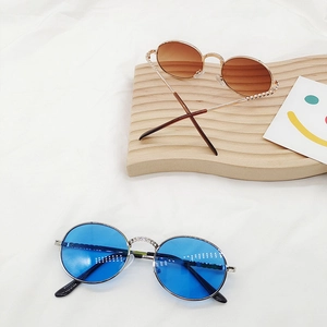 Detailed macro of vintage round metal frames with blue and gradient lenses for kids