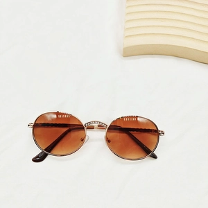 Detail of rose gold metal frame kids sunglasses with pearl accents and UV400 lenses