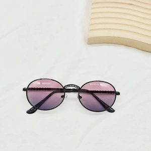 Detail of round kids sunglasses featuring purple gradient lenses and rhinestone bridge