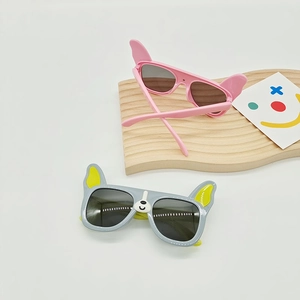 Detail of pink and gray dog-shaped kids sunglasses with UV protection lenses