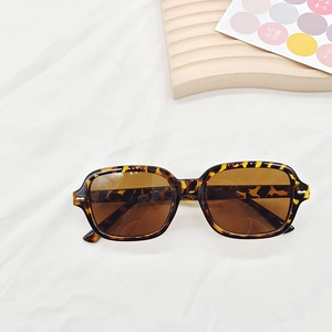 Détail de lunettes de soleil rétro en écaille avec verres bruns et rivets dorés en métal