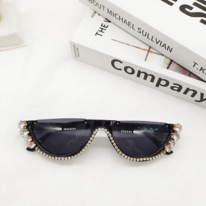 Detailed macro view of diamond-encrusted half-frame sunglasses with gold metal temples